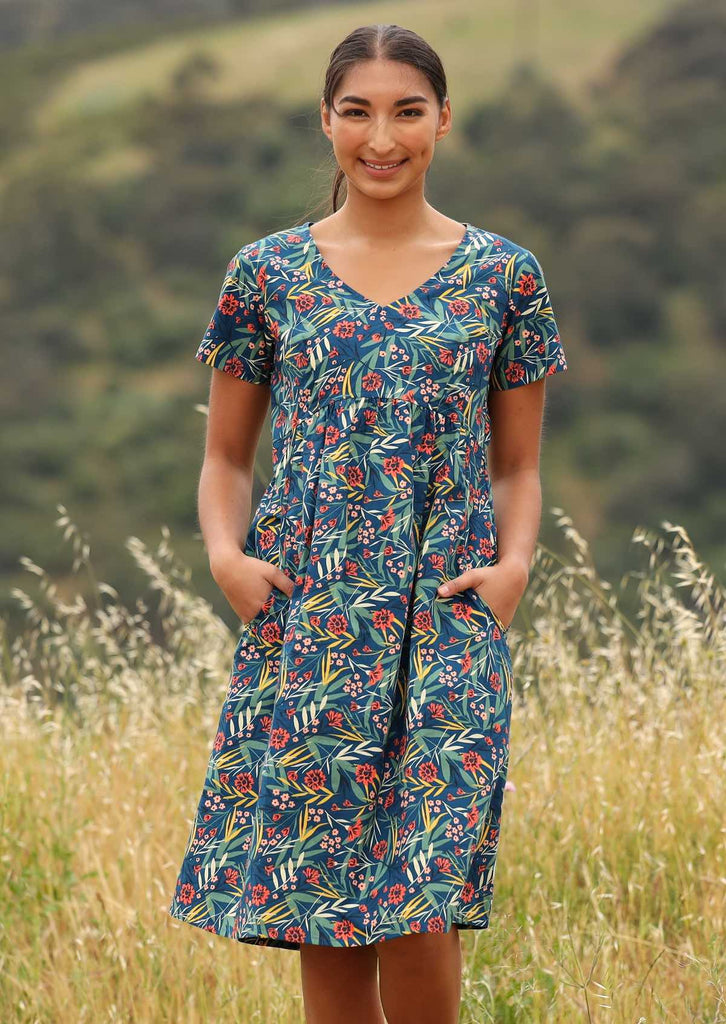 Model wears knee length dress with a V neckline. 