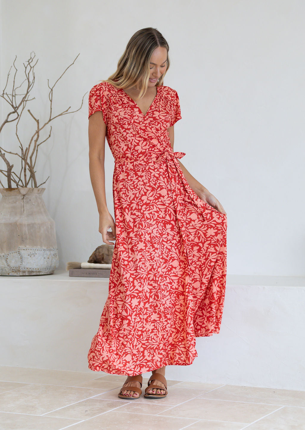Woman wearing orange wrap around maxi dress 