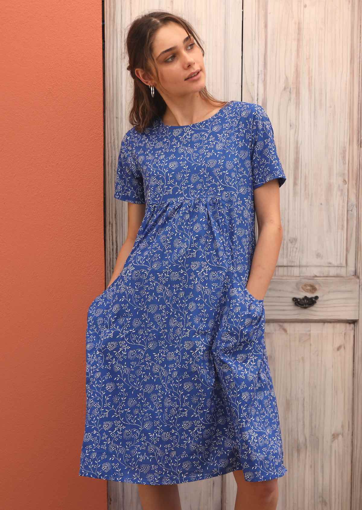 Model puts hands in the pockets of her loose-fitting dress. 
