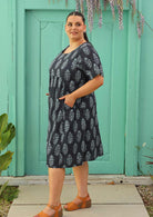plus sized model wearing navy blue cotton dress with Indian print and pockets