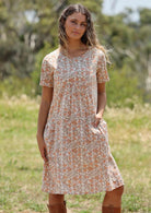 Woman in forest with light coloured floral cotton dress with pockets