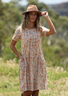 Woman in forest with light coloured floral cotton Frankie dress with pockets