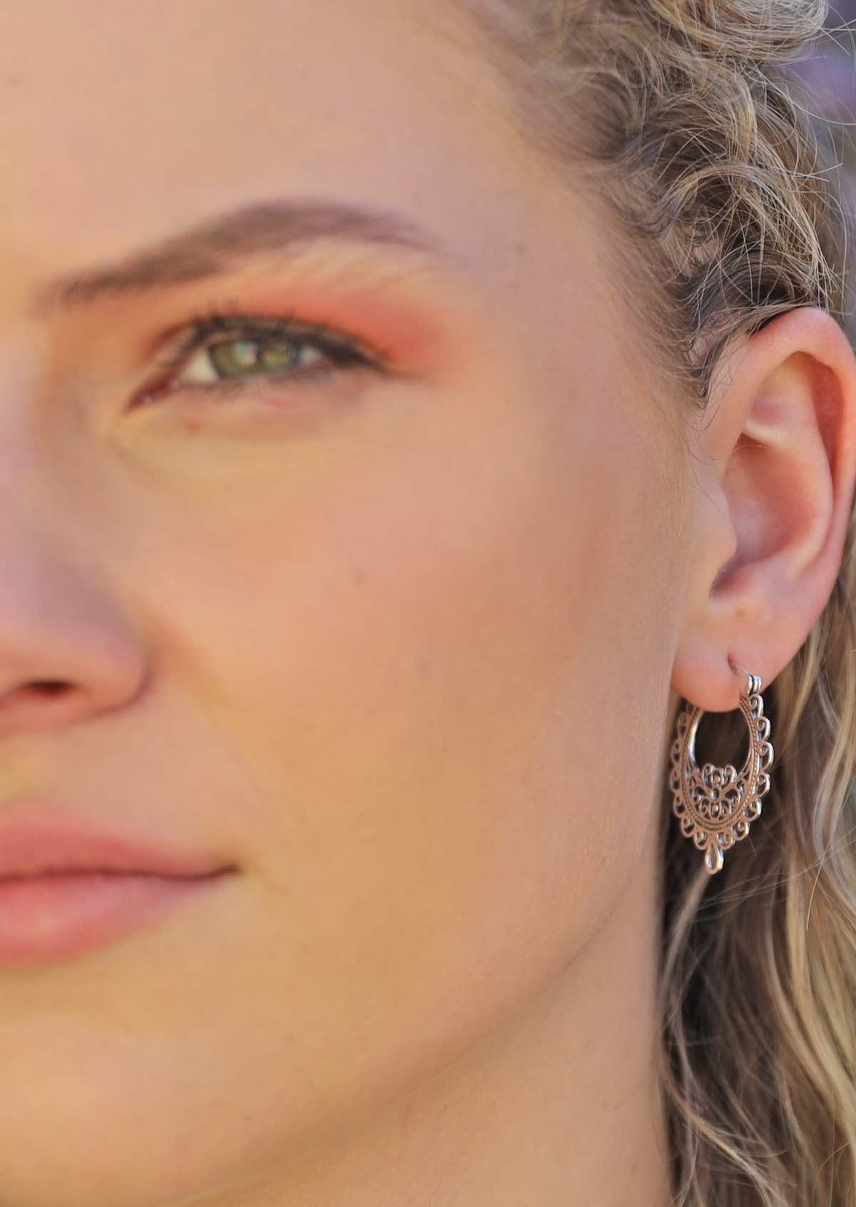 model wearing ornate boho silver hoop earrings