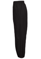 Side view of wide leg black cotton pants with elastic waist, pockets and pleated ankles 