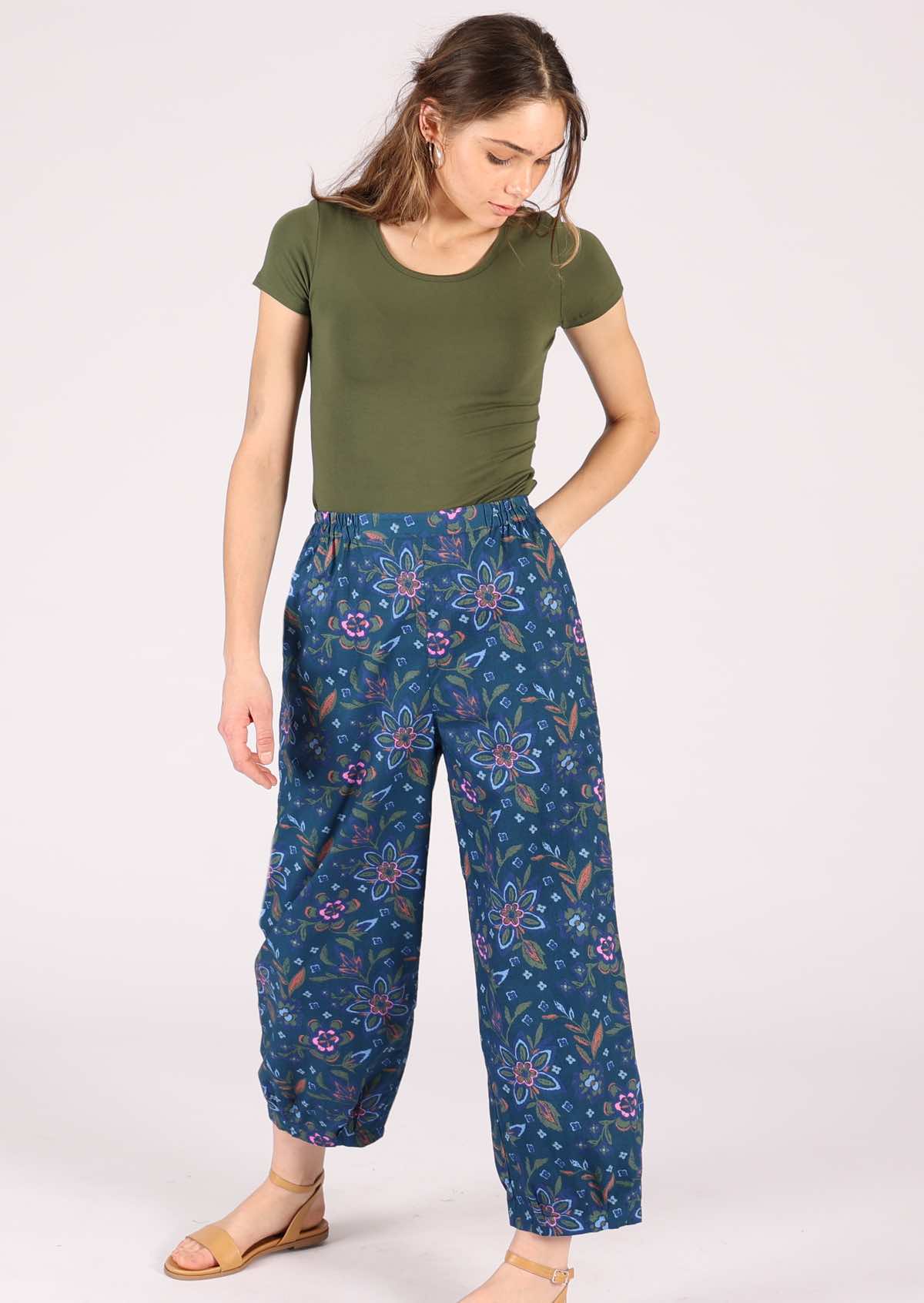 Model wears cotton pants with elastic at either side of the waist. 