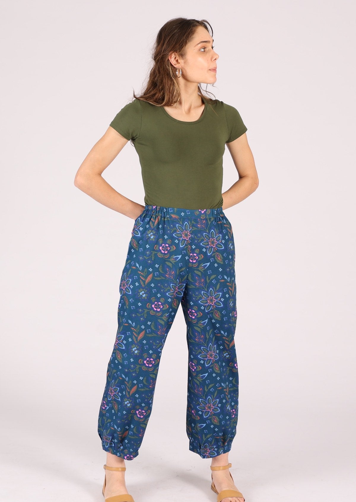 Model pairs blue cotton pants with a plain top and sandals. 