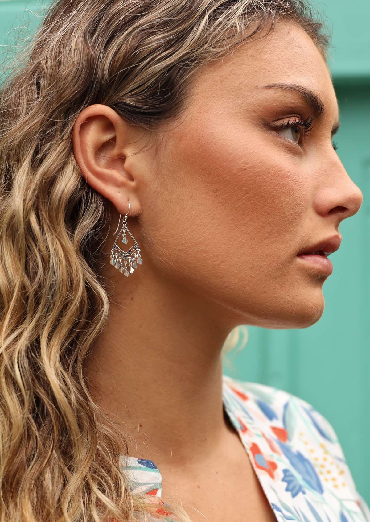 Woman wearing Boho silver diamond shaped silver earring