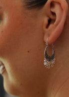 silver boho earrings with dangly stars on woman's ear