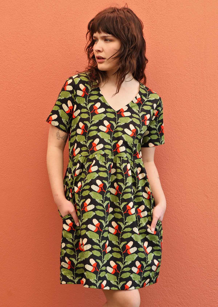 Model wears Harlow Dress Oak cotton V-neck loose fitting above knee dress with hidden side pockets 