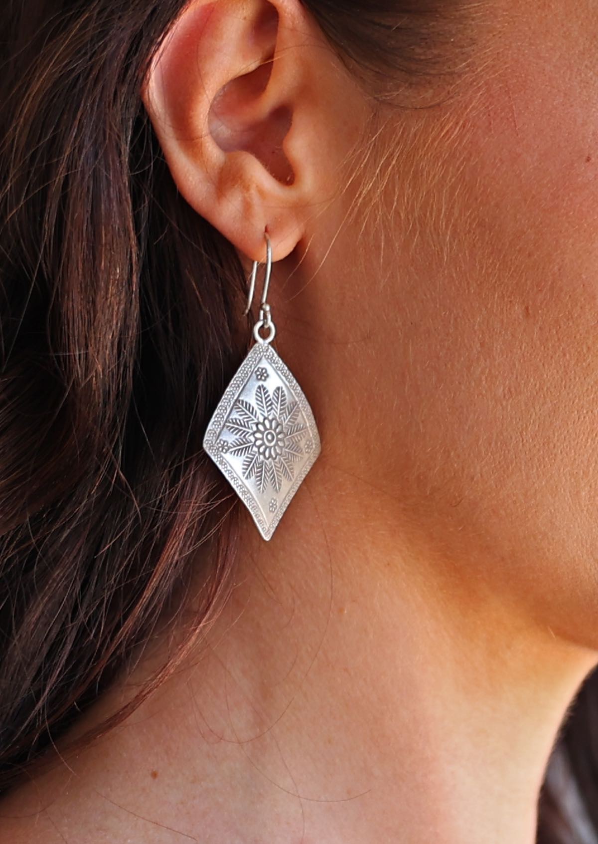 Silver Large Hill Tribe earrings worn by a person with dark hair.