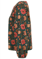 Side view of 100% cotton bishop sleeves top in bright floral print on deep green base.