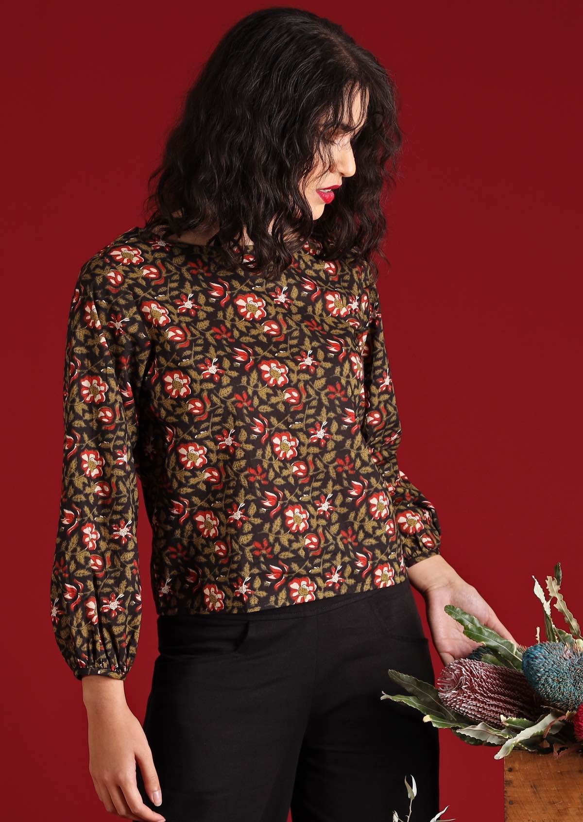 Model with dark hair and red lipstick in Isla Top Wild Rose floral cotton boho top