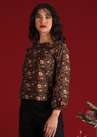 Model with dark hair and red lipstick in Isla Top Wild Rose black floral cotton top