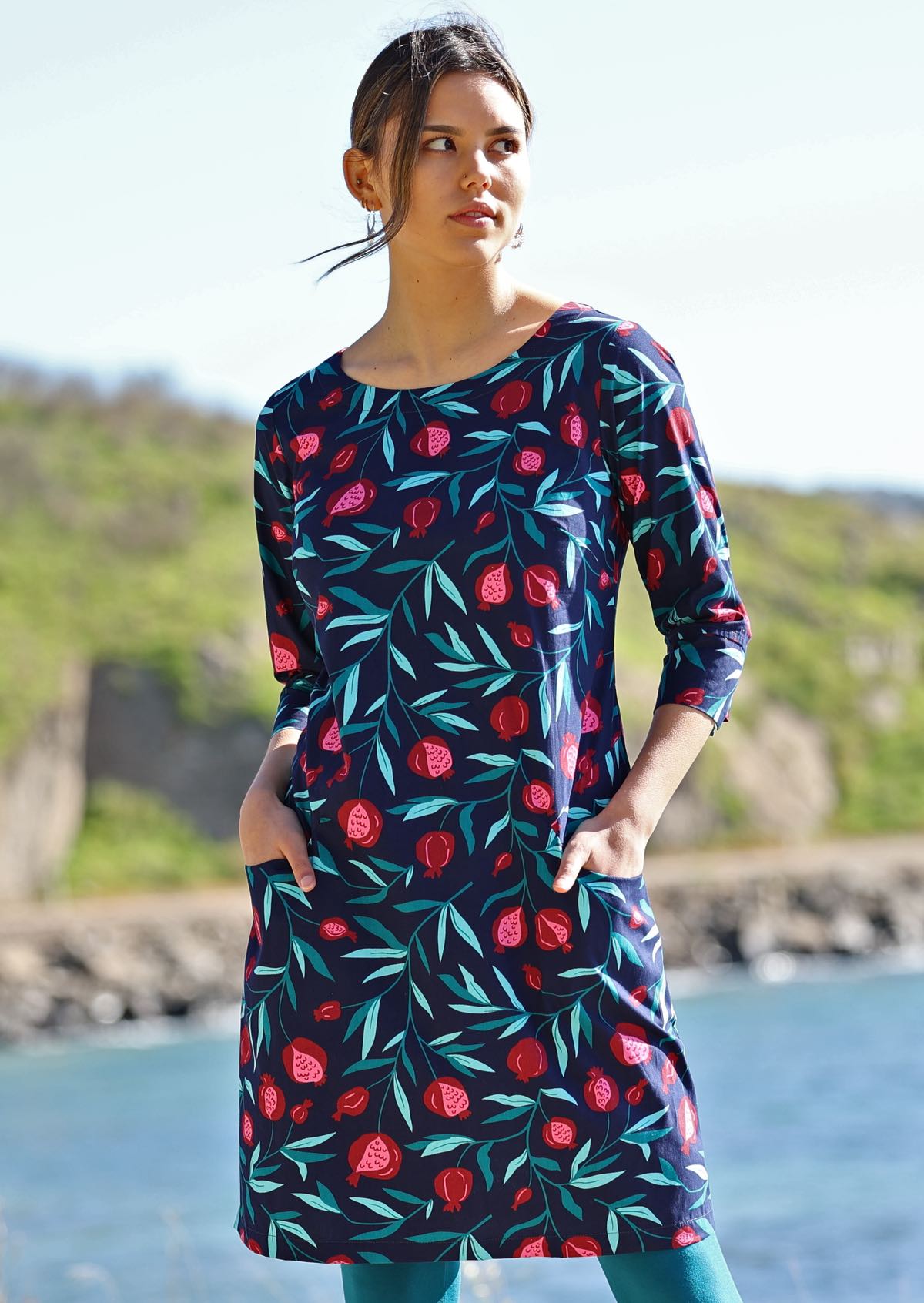 Model wears 100% cotton dress with pink red fruit print on blue base