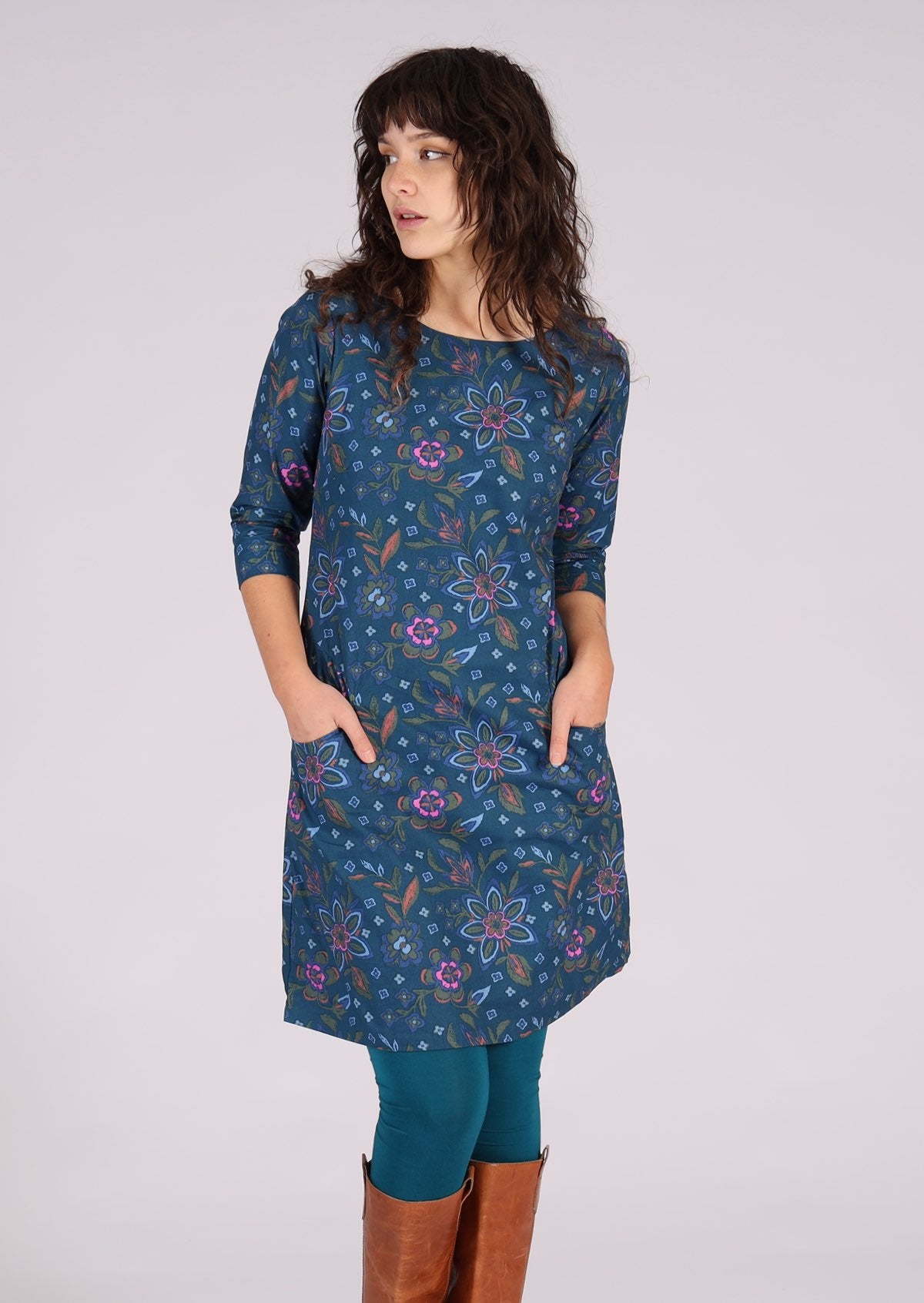 woman wearing navy floral long sleeve tunic dress with hands in pockets