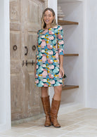 Woman wearing a colorful dress with abstract pattern and 3/4 sleeves with cuffed detailing