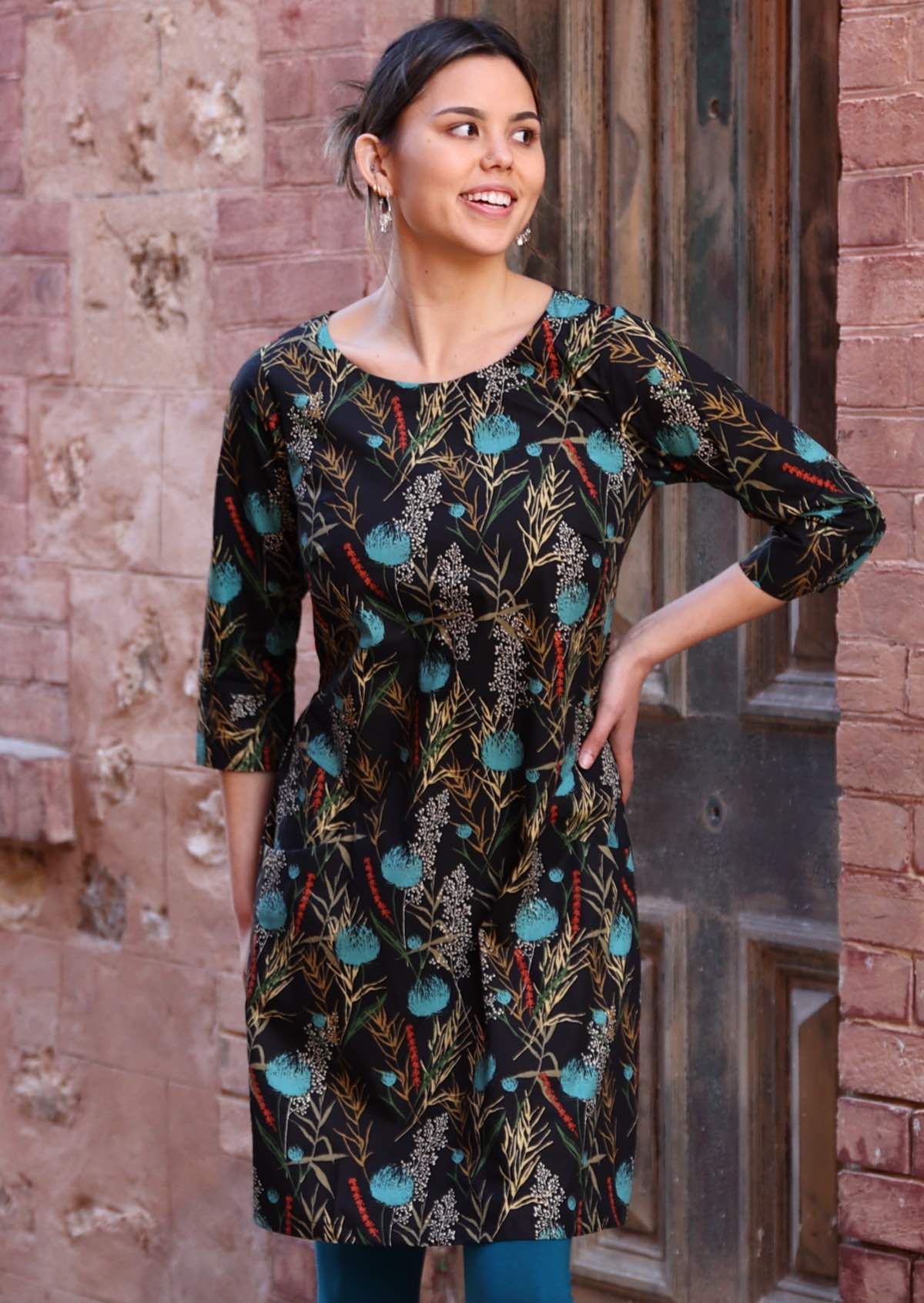 Model wears dramatic botanical print cotton dress with black base