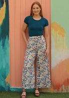 Model wears wide leg pants with a floral pattern. 