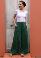 Model wears green, wide legged pants. 