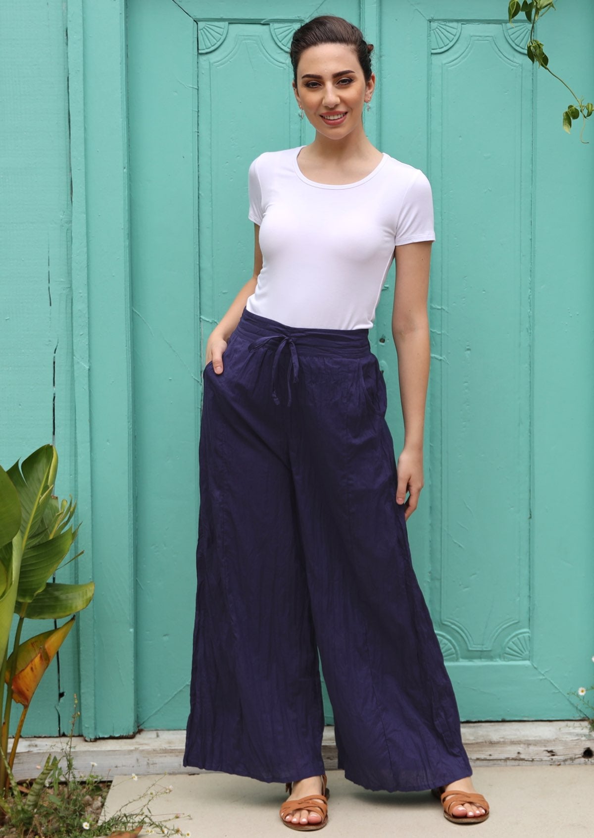 Model wears flowing pants with a drawstring at the front. 