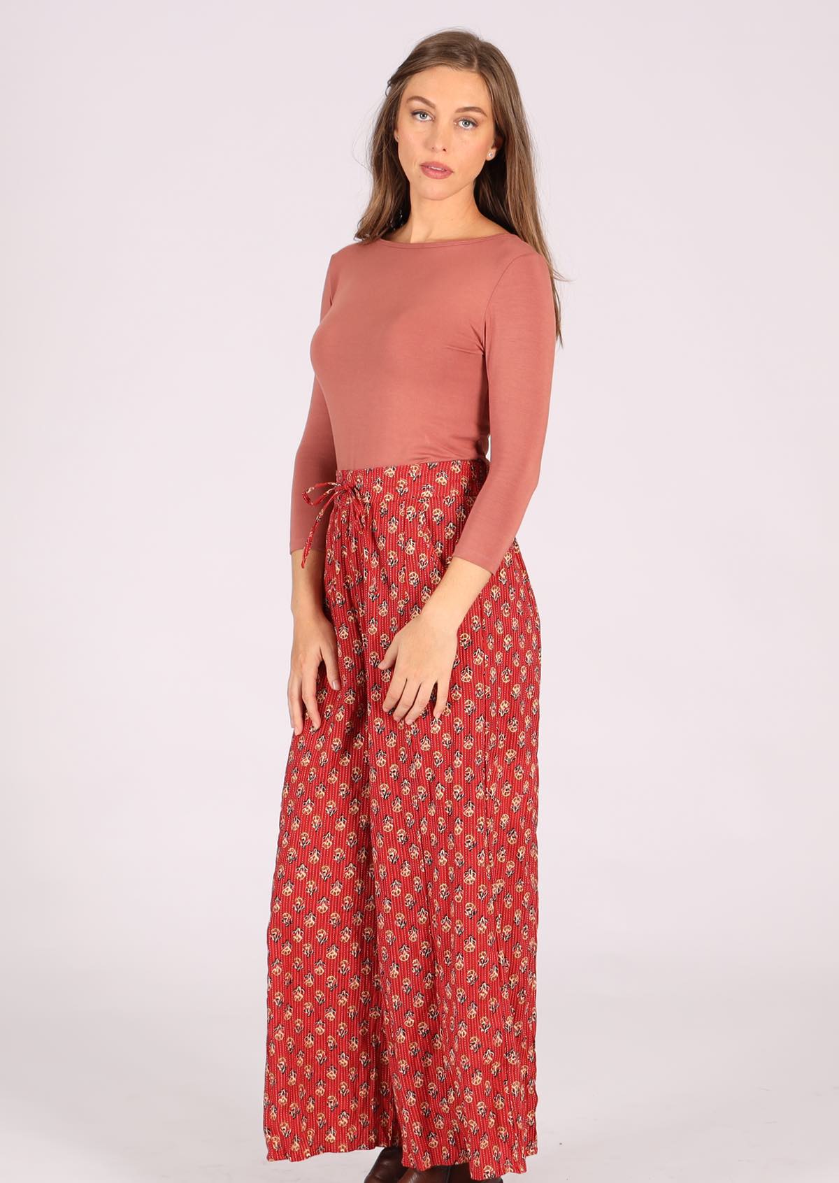 Lightweight cotton pants with flower print on burnt red base