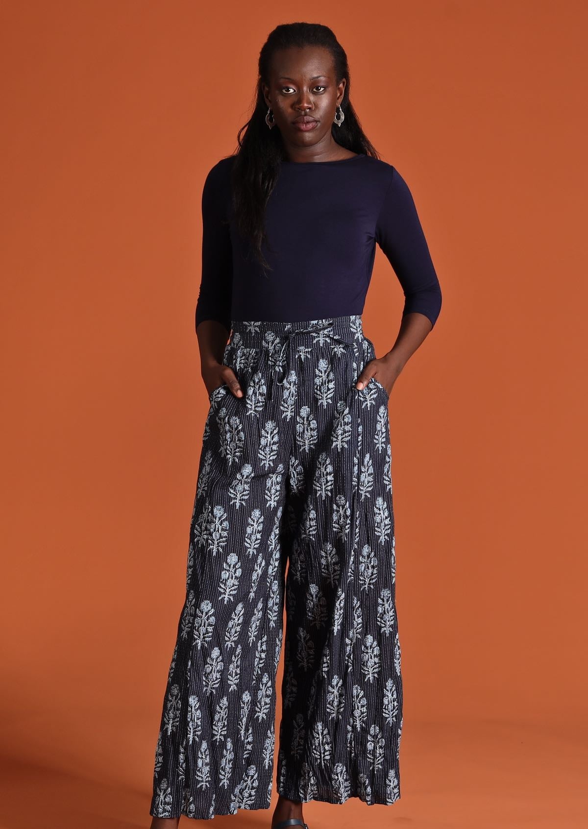 Model wearing wide legged women's cotton pants and long sleeve navy stretch top
