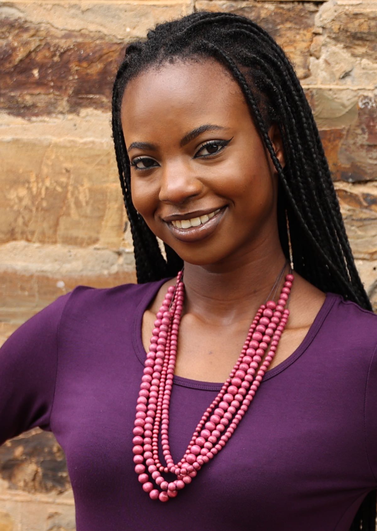 Four strands of different sized wooden beads in pink