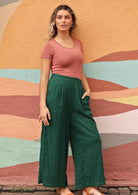 model standing with one hand in pocket of green pants 