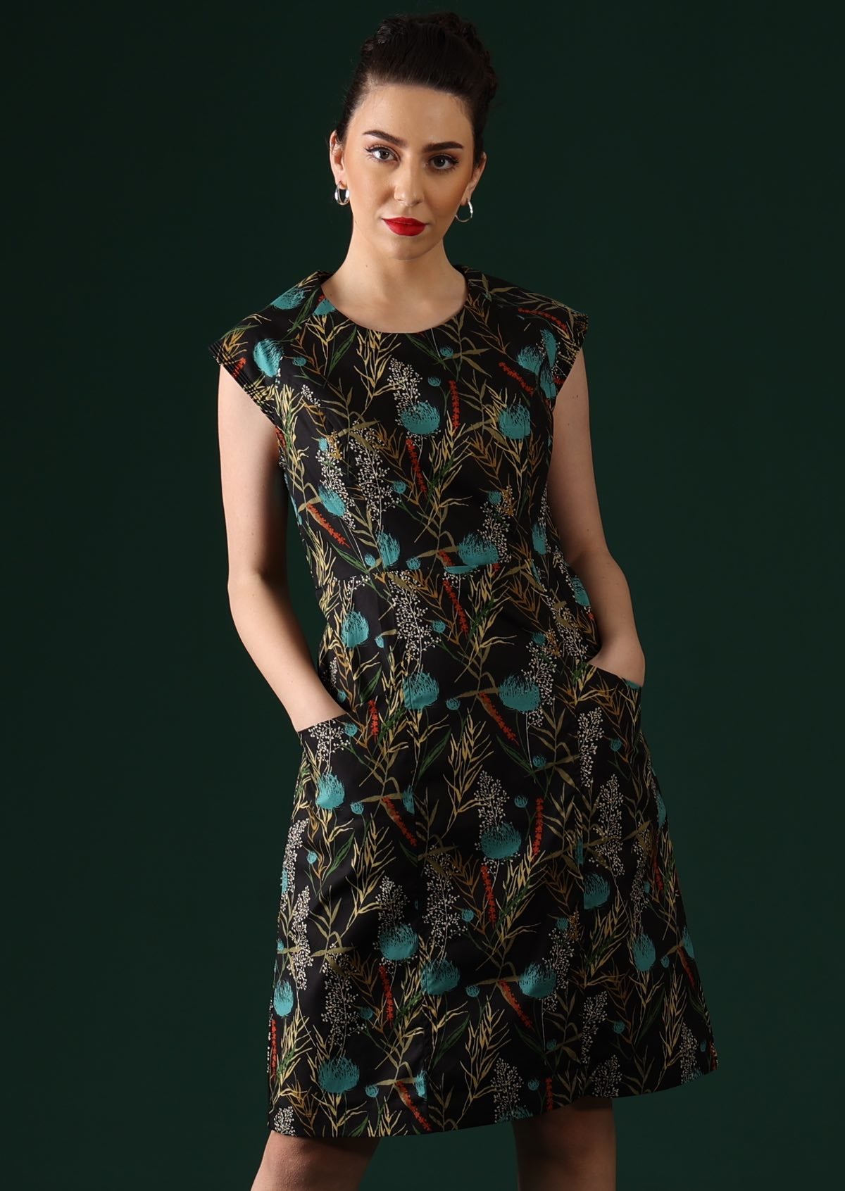 Model wears floral dress with cap sleeves.