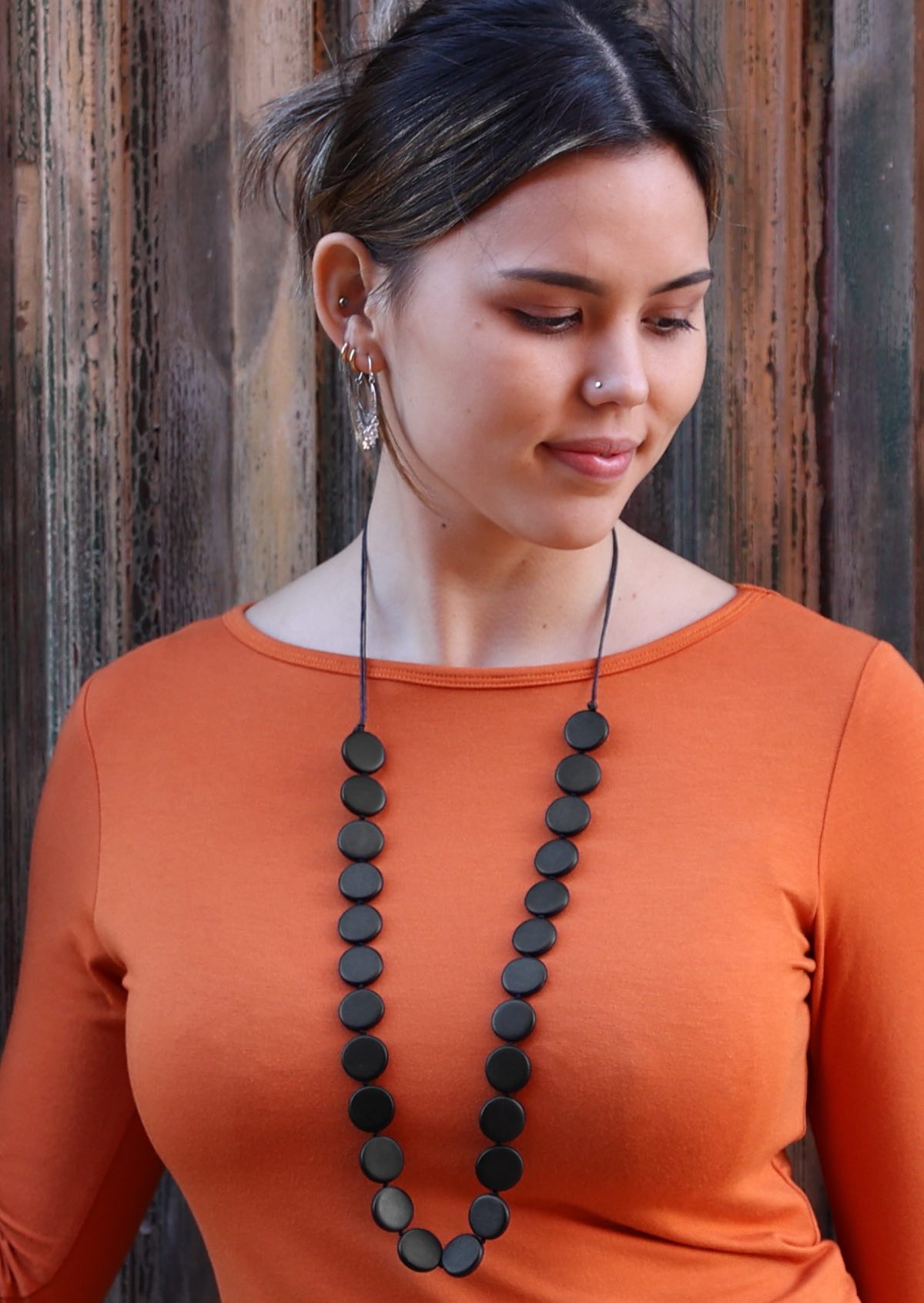 Women wears 90cm long fair trade necklace with hand sculpted wooden beads.