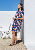 Black haired model wears above knee length 100% cotton dress with hidden side pockets and short sleeves,