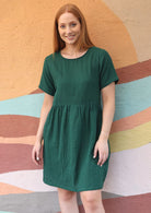 model smiling at camera in green mabel dress 