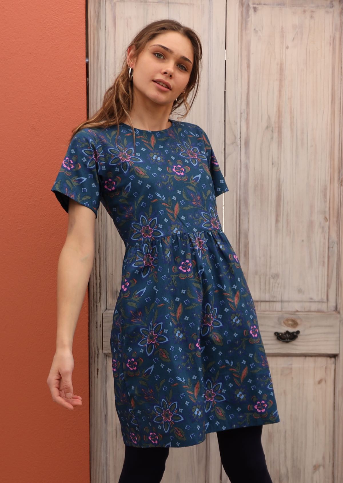 Model wears 100% cotton dress with a blue base and short sleeves.