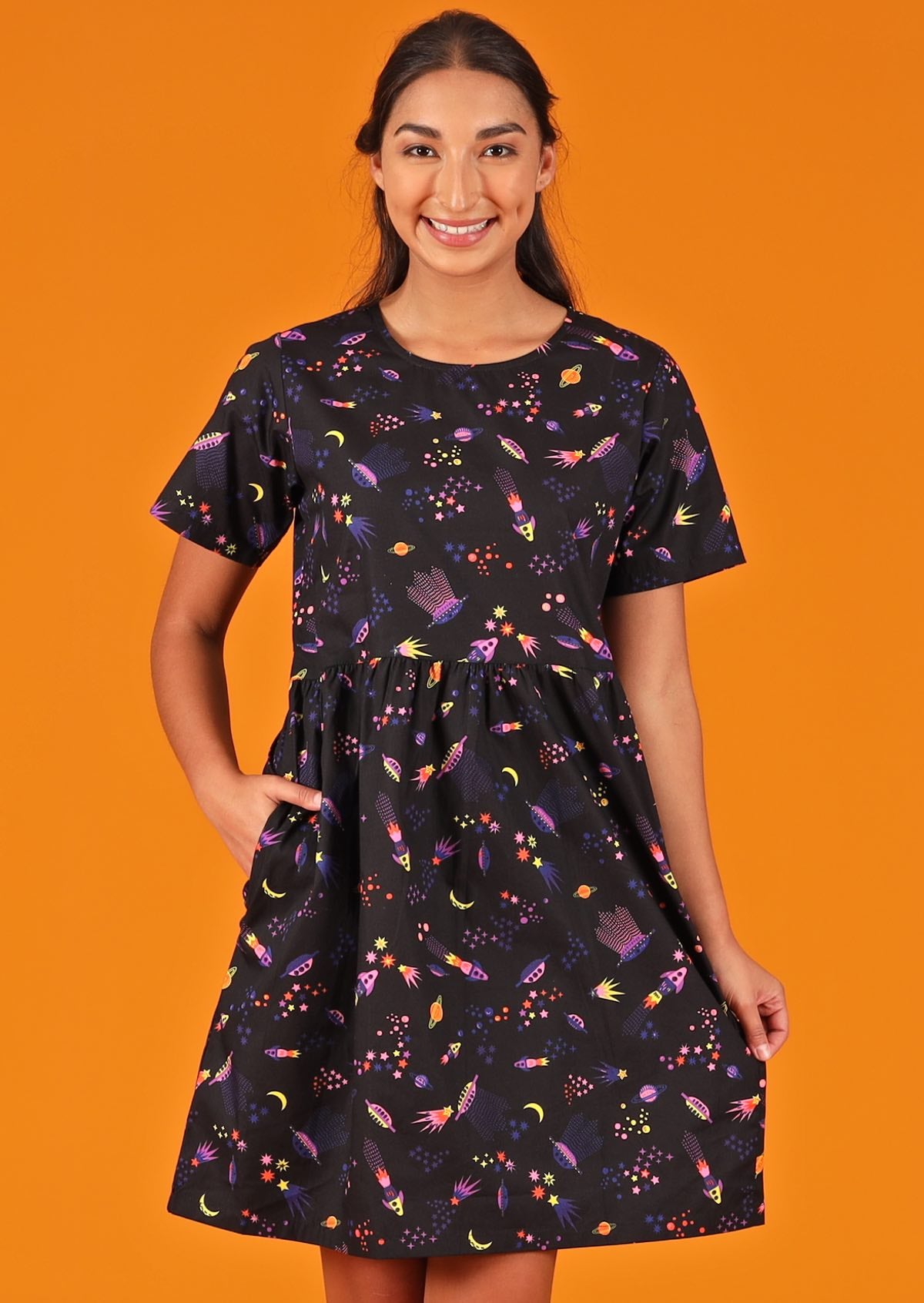 Model is mabel Dress Astro 100% cotton space print on black background relaxed fit above knee dress with hidden pockets 