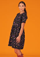 Woman in round neck short sleeve cotton dress showing side view