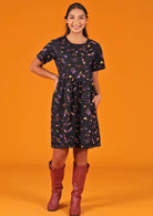Model in relaxed fit cotton space print dress with arm on waist. 