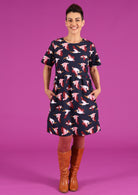 Model wearing 100% cotton pelican print on dark blue base relaxed fit short sleeve dress with pockets 
