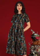 Model wears dark floral cotton dress with pockets
