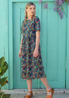 Model wears a cotton dress with a high, round neckline. 