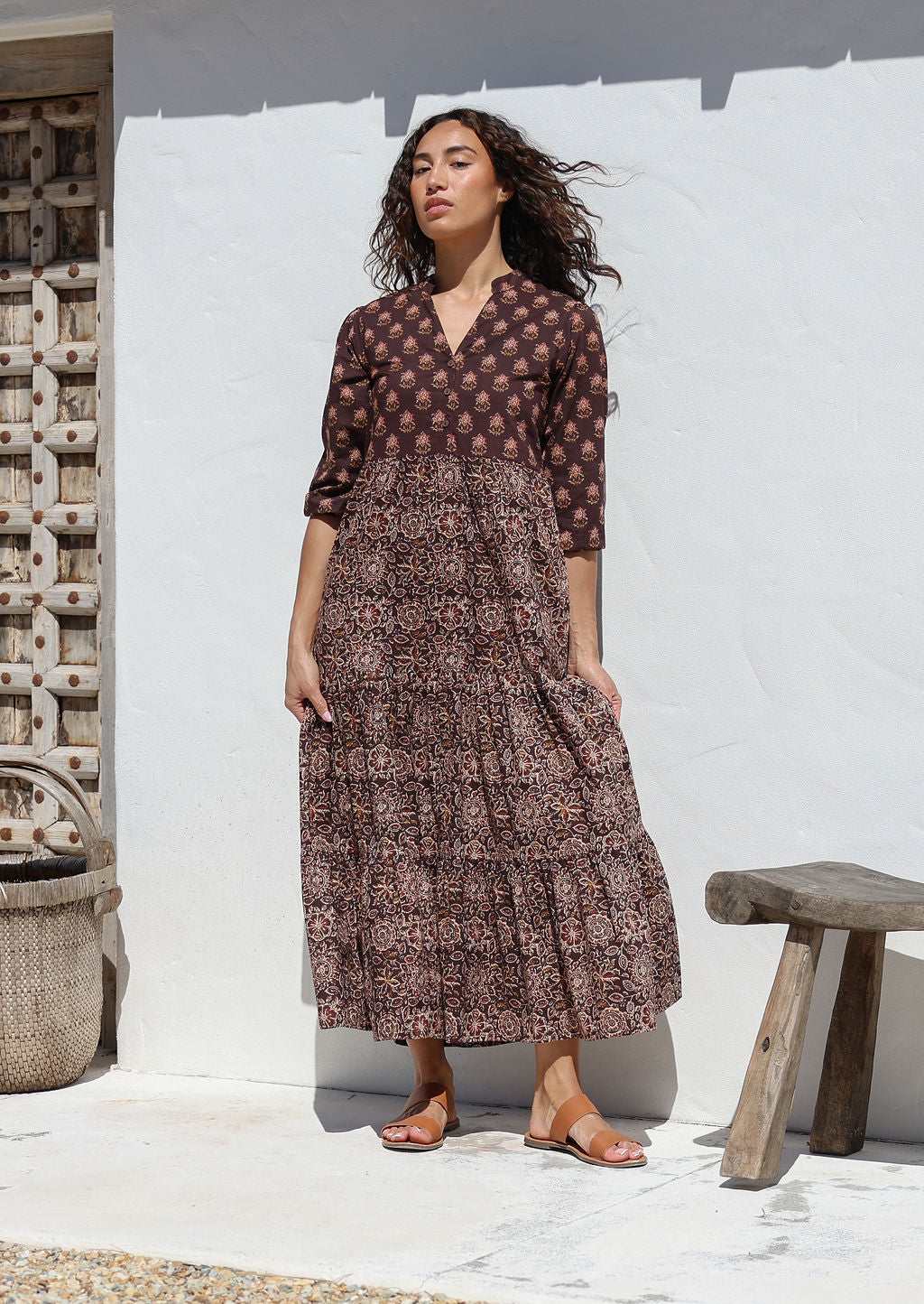 Woman wearing an Indian Cotton maxi dress standing against a white wall with hands in pockets 