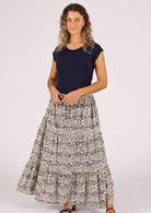 Model wears cotton maxi skirt with blue floral print on a cream base