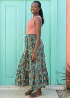 Smiling model shows the side profile of her maxi skirt. 