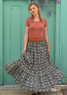 Model pairs long skirt with a belt on the waist. 