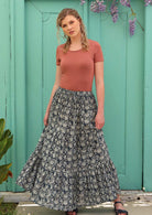 Blonde woman wears a three tiered skirt. 