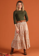 Model wears a 100% cotton maxi skirt with an elasticated waistband. Tiers of fabric create volume to this cream and peach patterned skirt. 