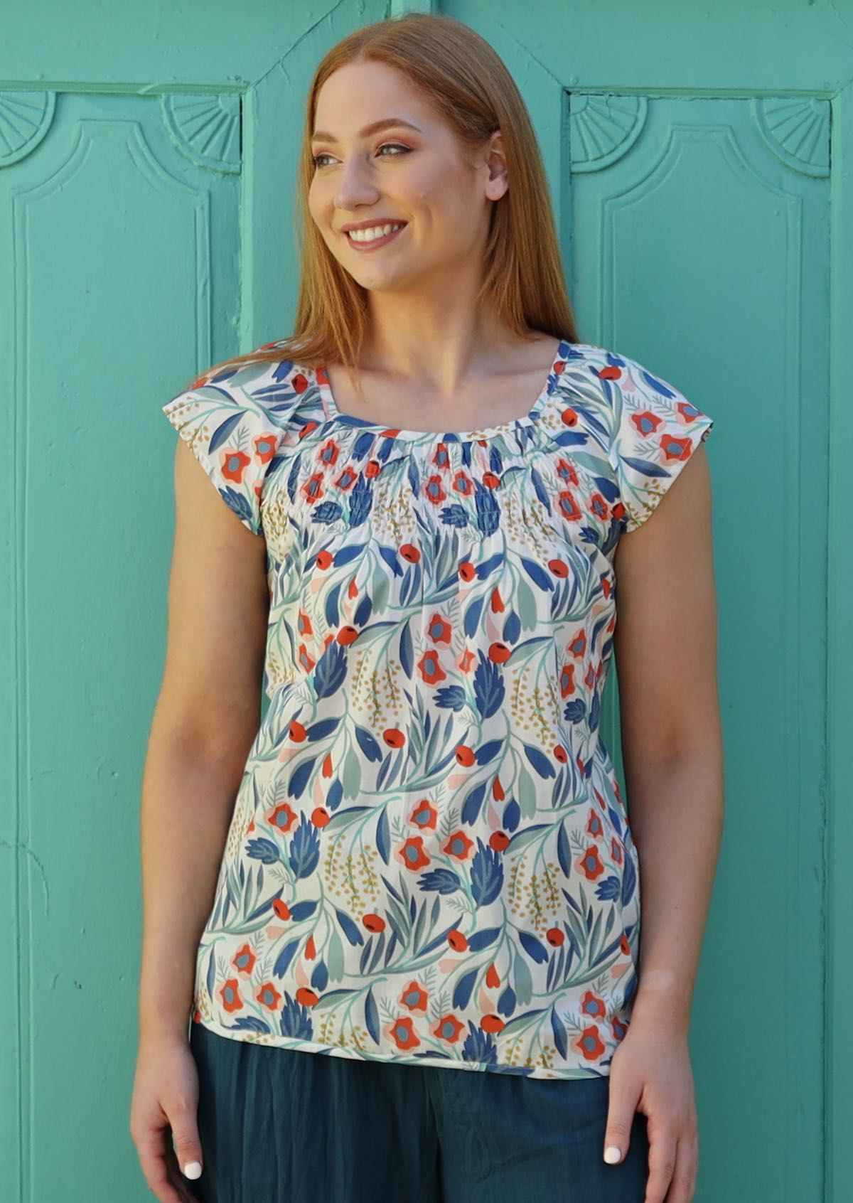 Model wears cotton floral top with squared off boat neckline