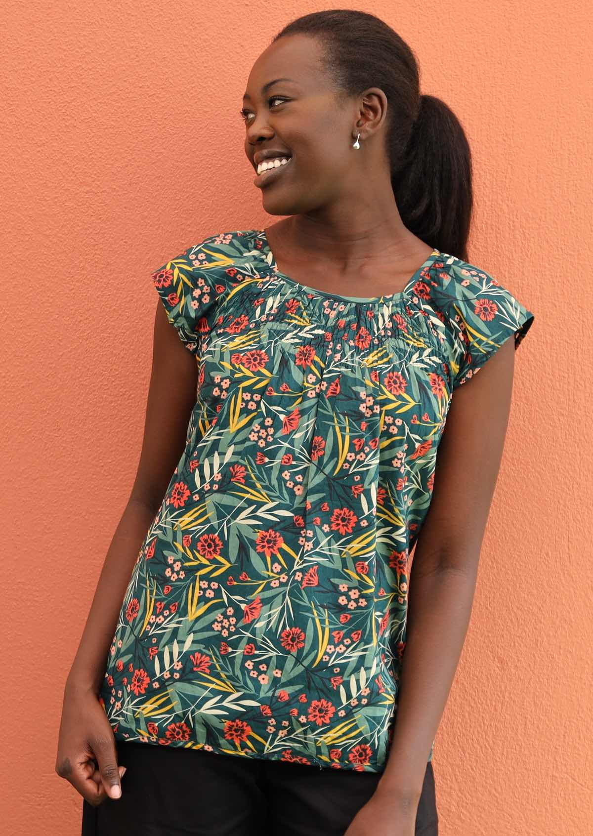 Smiling model wears 100% cotton top with green, pink and yellow florals. 