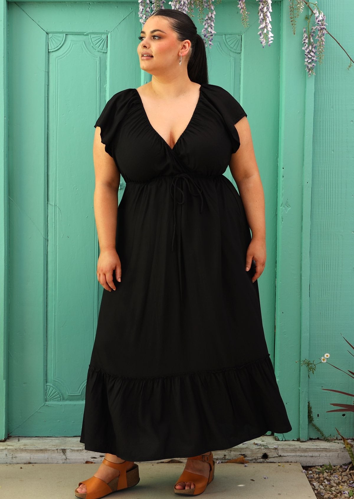 Curve sized woman wearing black rayon maxi dress with v-neck