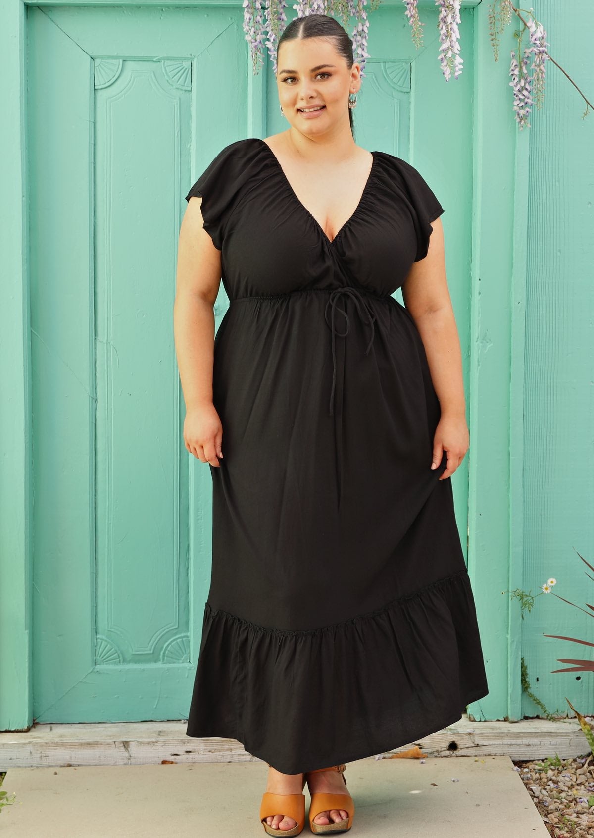 size 18 woman wearing black maxi dress