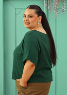 side view of curve sized model wearing double cotton gauze green boxy blouse 